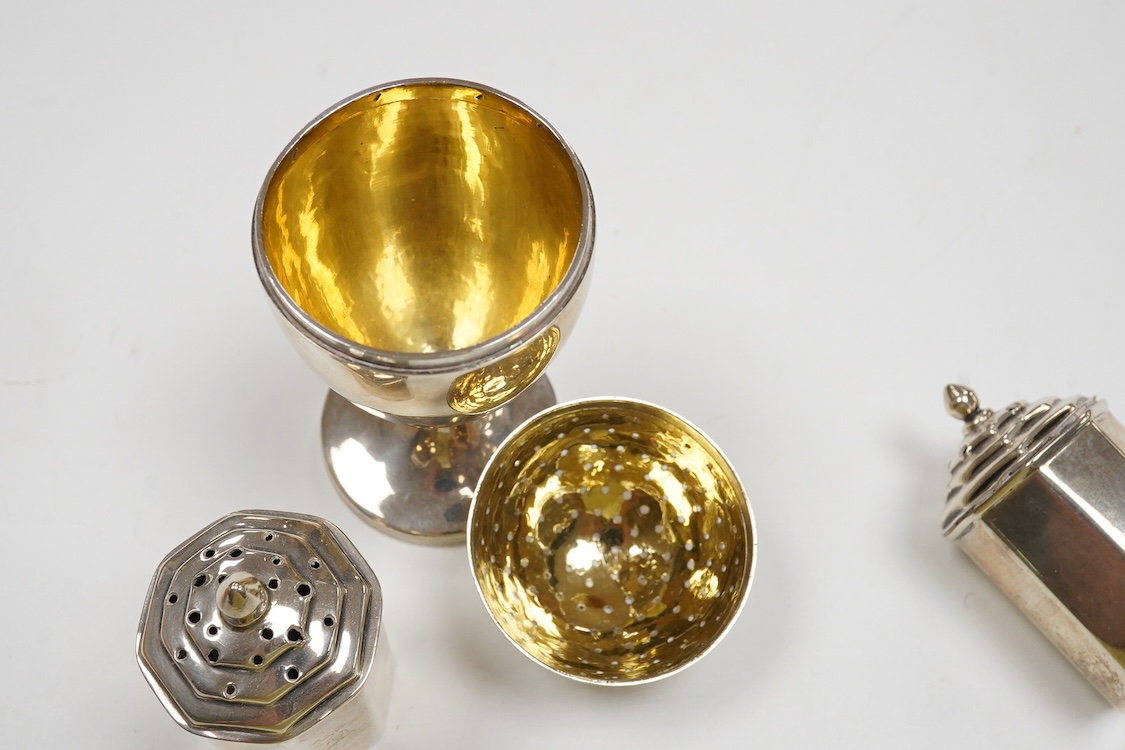 A George III provincial silver egg shaped pedestal pepperette, by Christian Ker Reid, Newcastle, circa, 1810, height 89mm, together with a pair of late Victorian octagonal pepperettes.